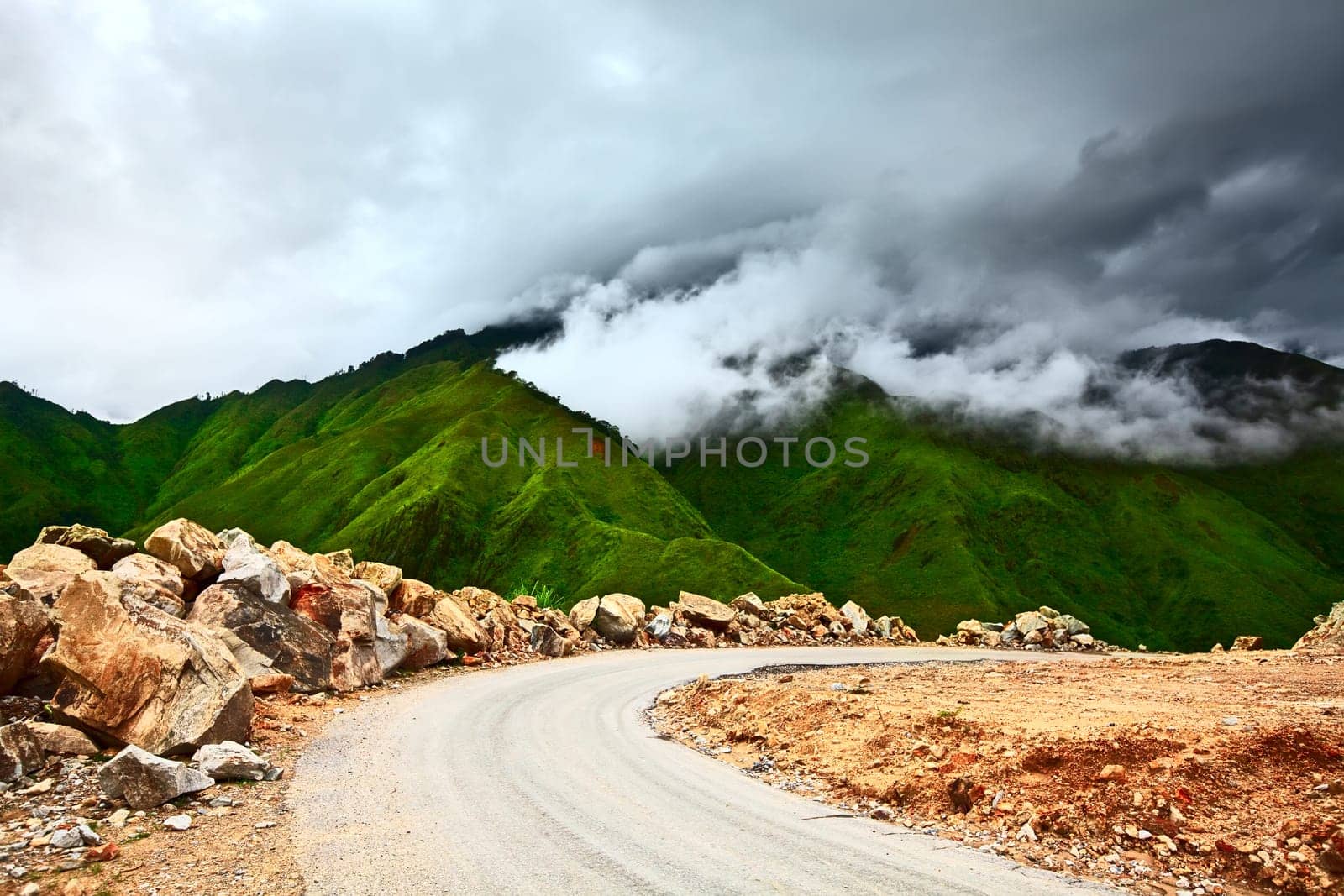 Mountain road at rainy day with clouds on the sky