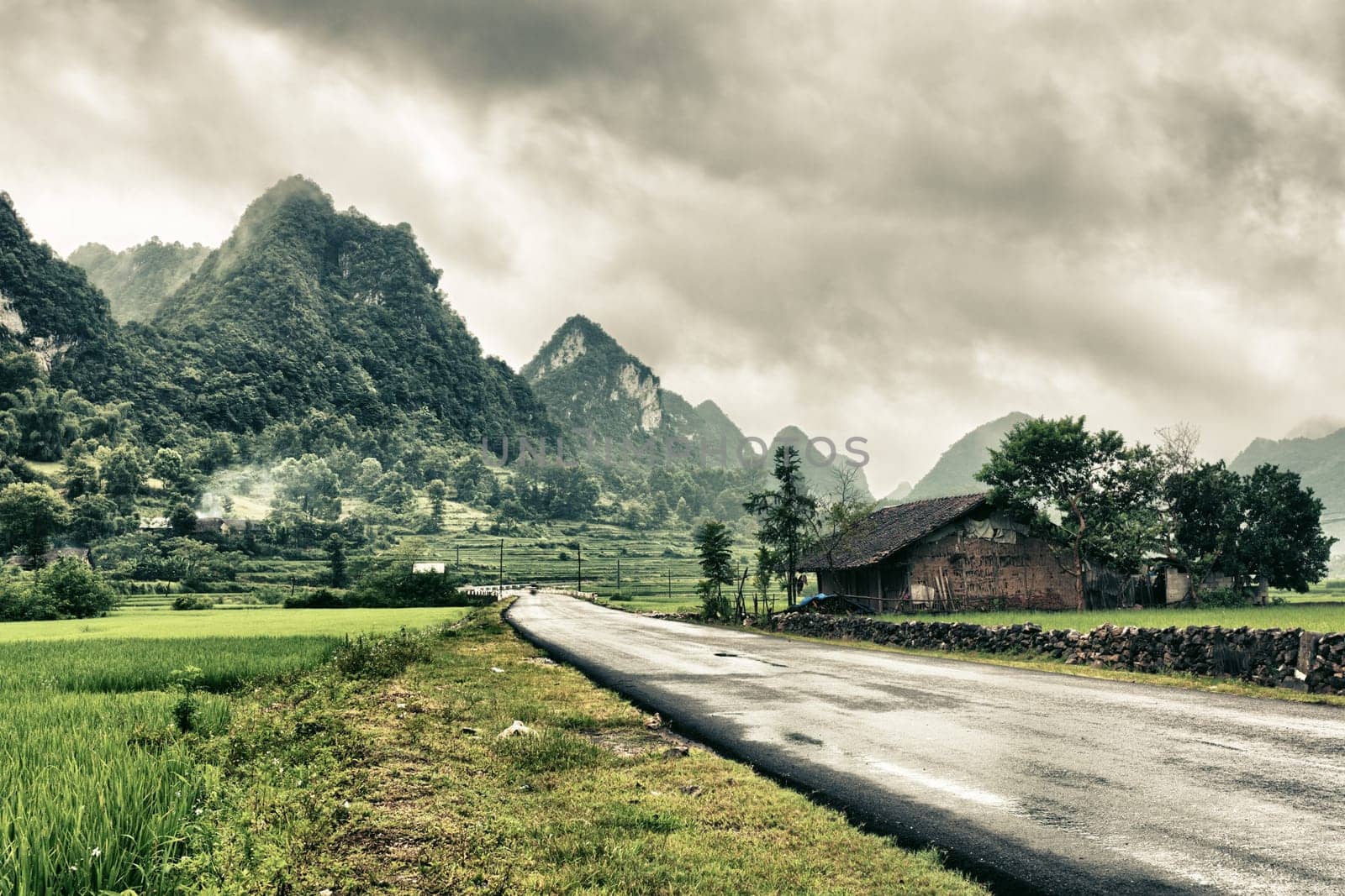 Rural landscape with road  house and mountains.