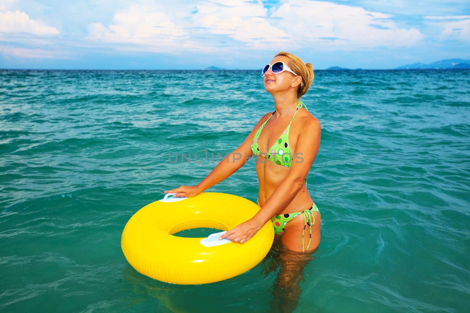 Funny woman with yellow tube in the sea