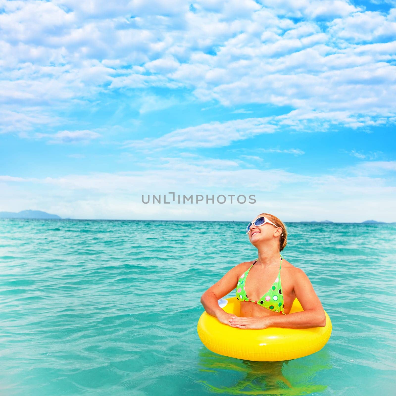 Woman with inflatable tube in clean blue ocean