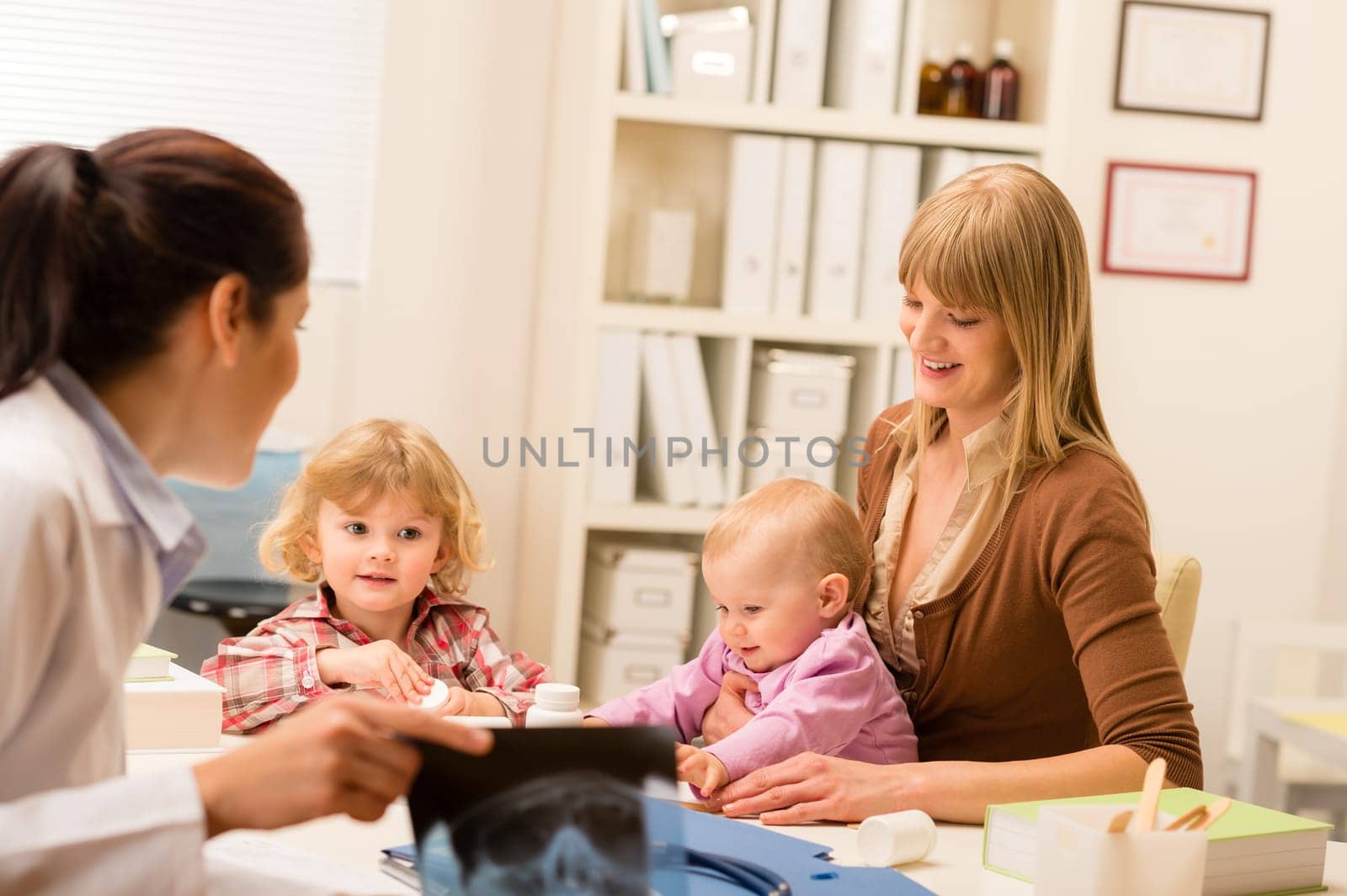 Young woman with little baby at pediatrician office show x-ray