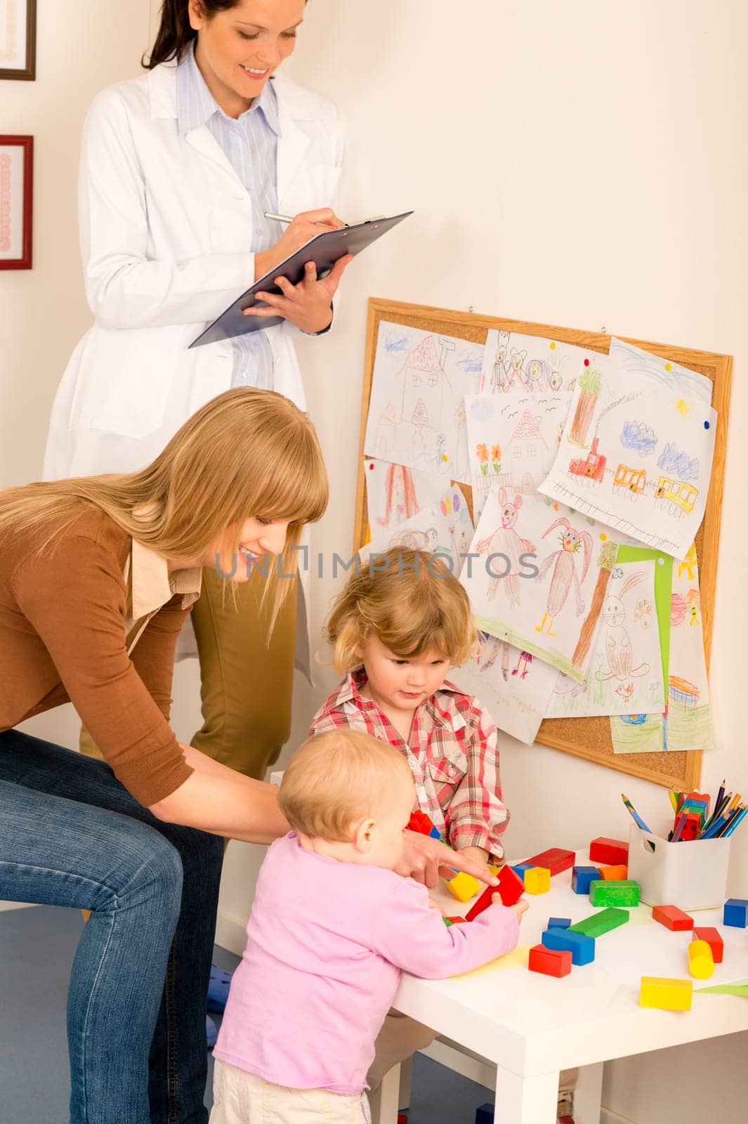 Pediatrician female observe children playing activity fill medical report