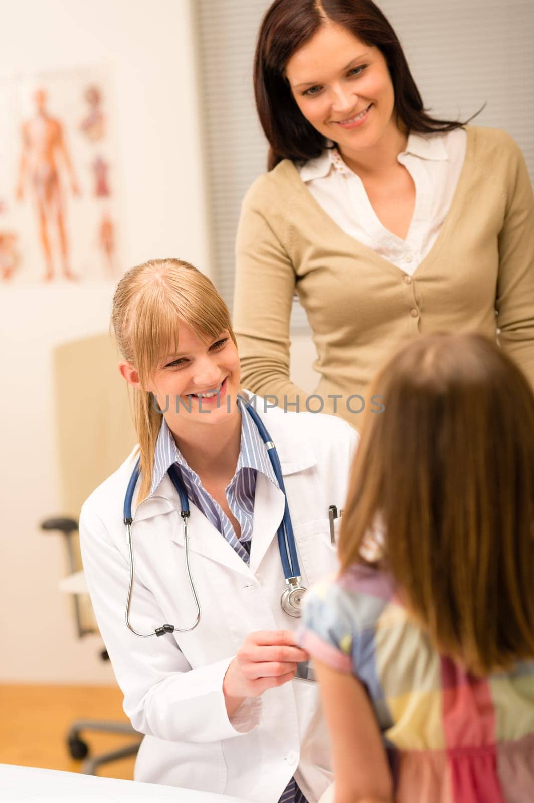 Pediatrician with little girl and mother at medical office