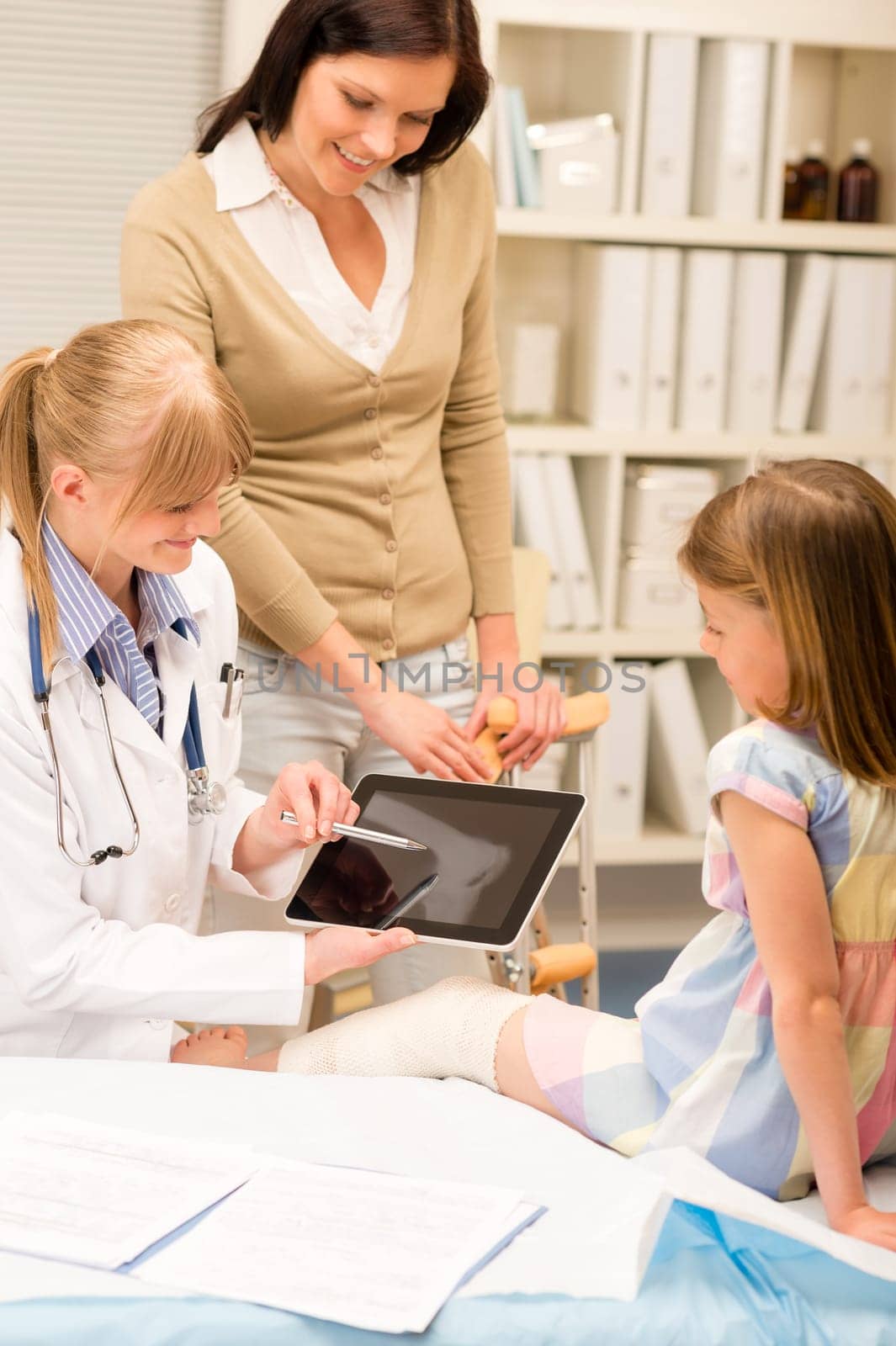 Pediatrician point at tablet x-ray girl broken leg medical office