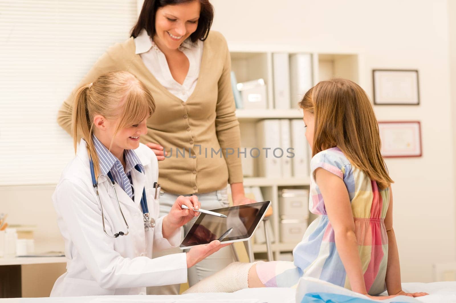 Pediatrician point at tablet x-ray girl broken leg medical office
