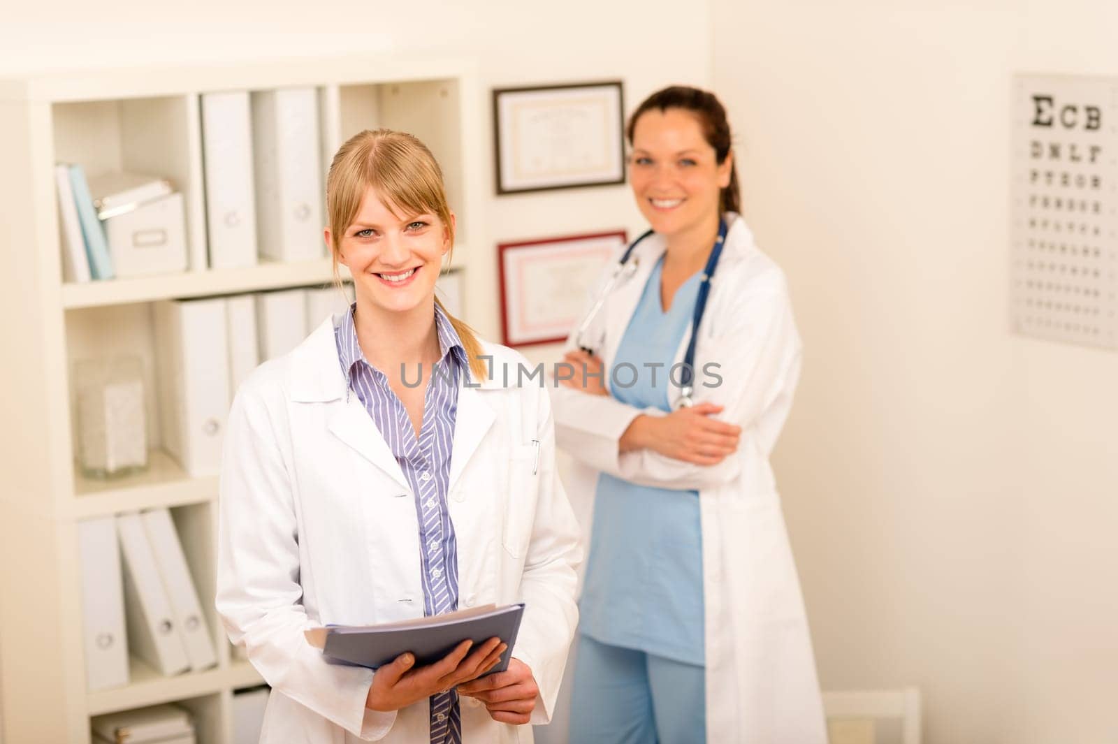 Portrait of two female doctors standing at medical office together