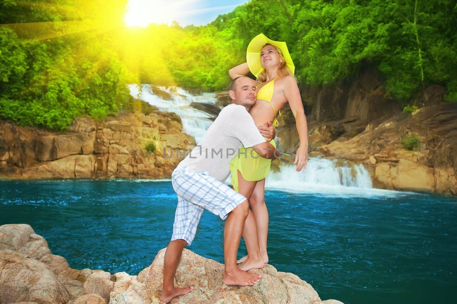 Couple near waterfall on sunrise time