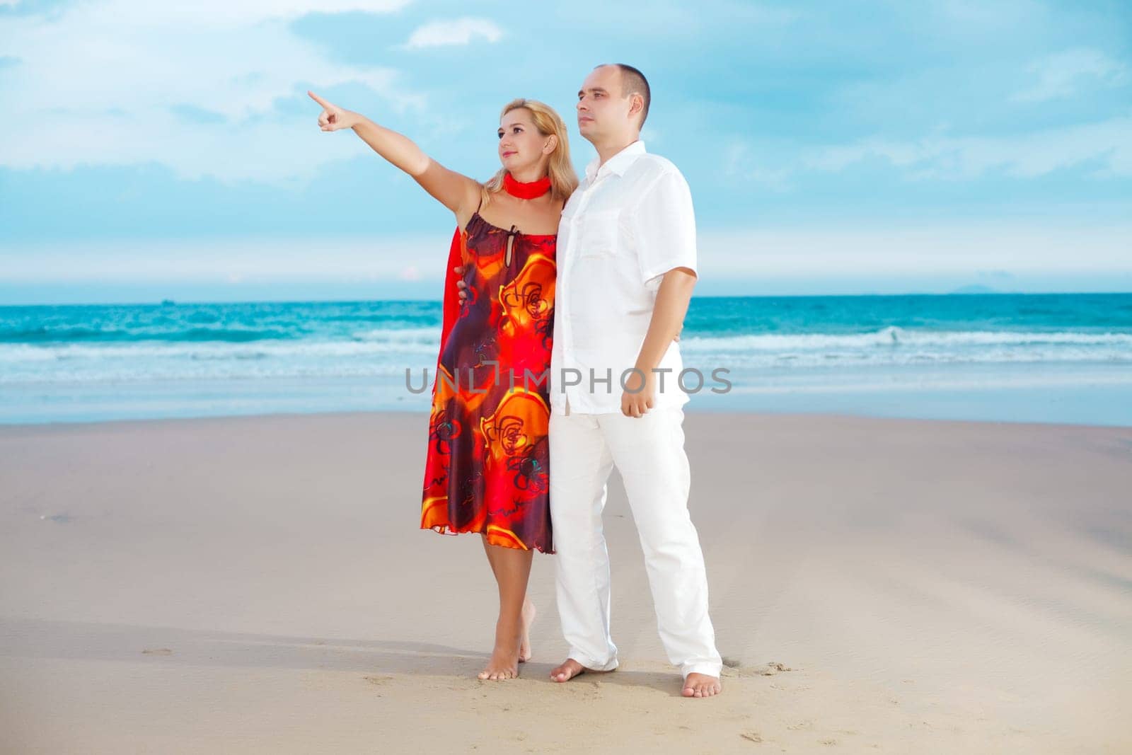 Woman showing something by finger near the ocean