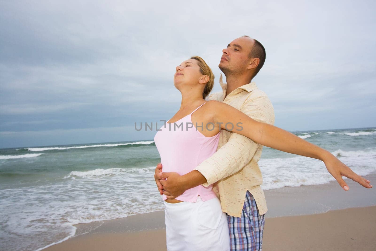 Young couple near the ocean on sunset time