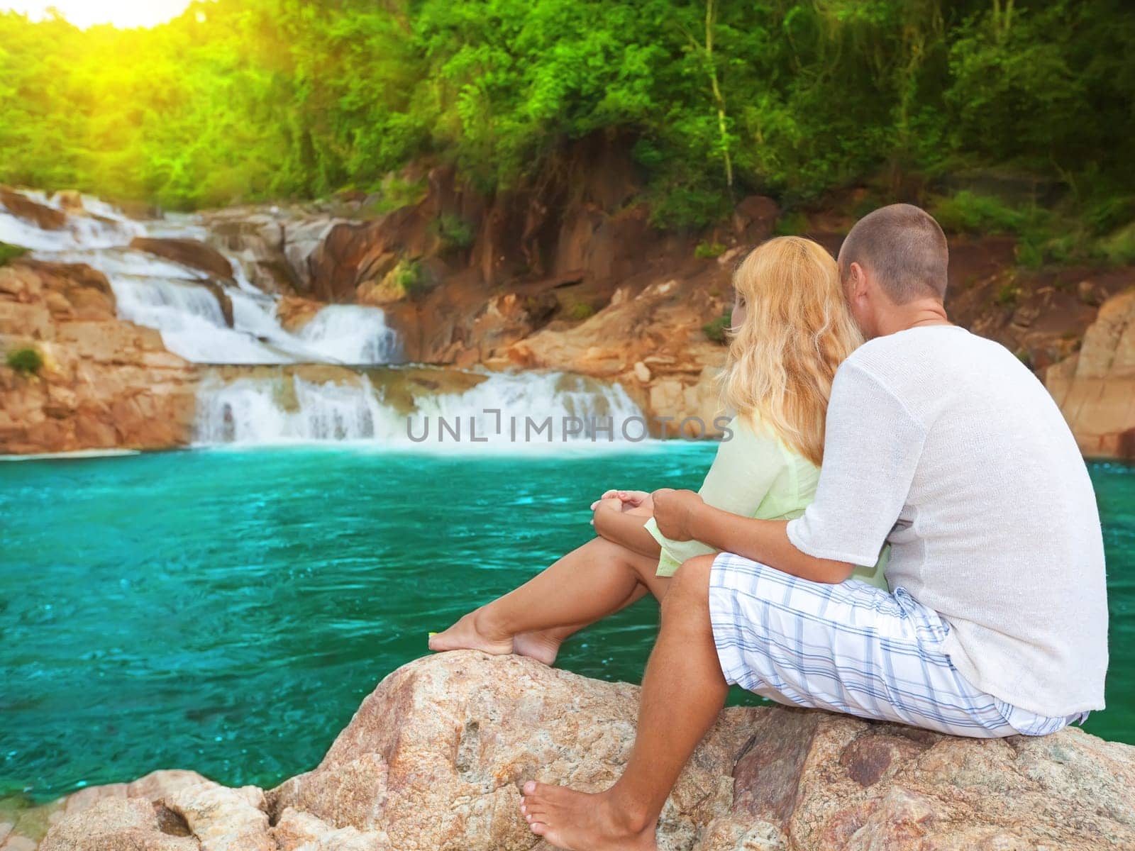 Couple near waterfall on sunrise time