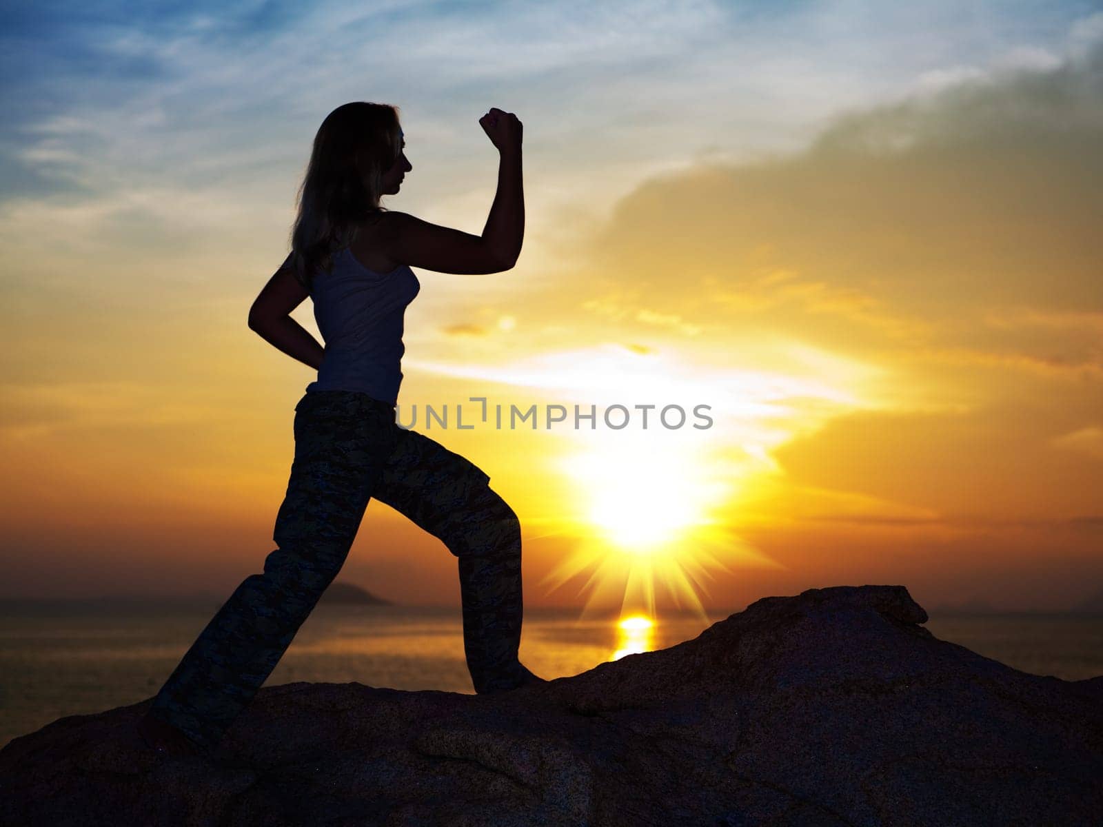 Silhouette of woman doin training exercise at sunrise time