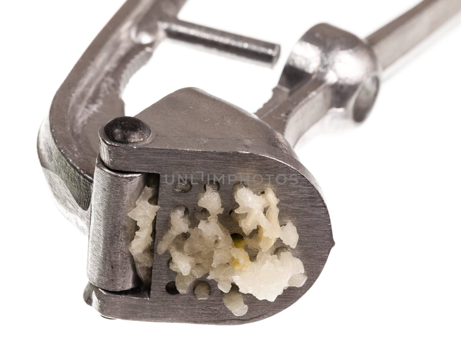 Garlic press and garlic isolated against white in macro shot