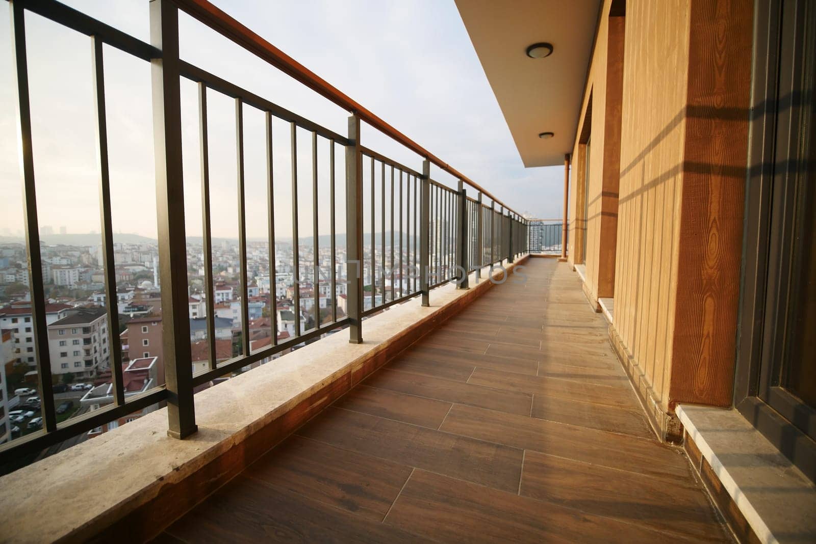 A stylish balcony overlooks a sprawling urban landscape during twilight.