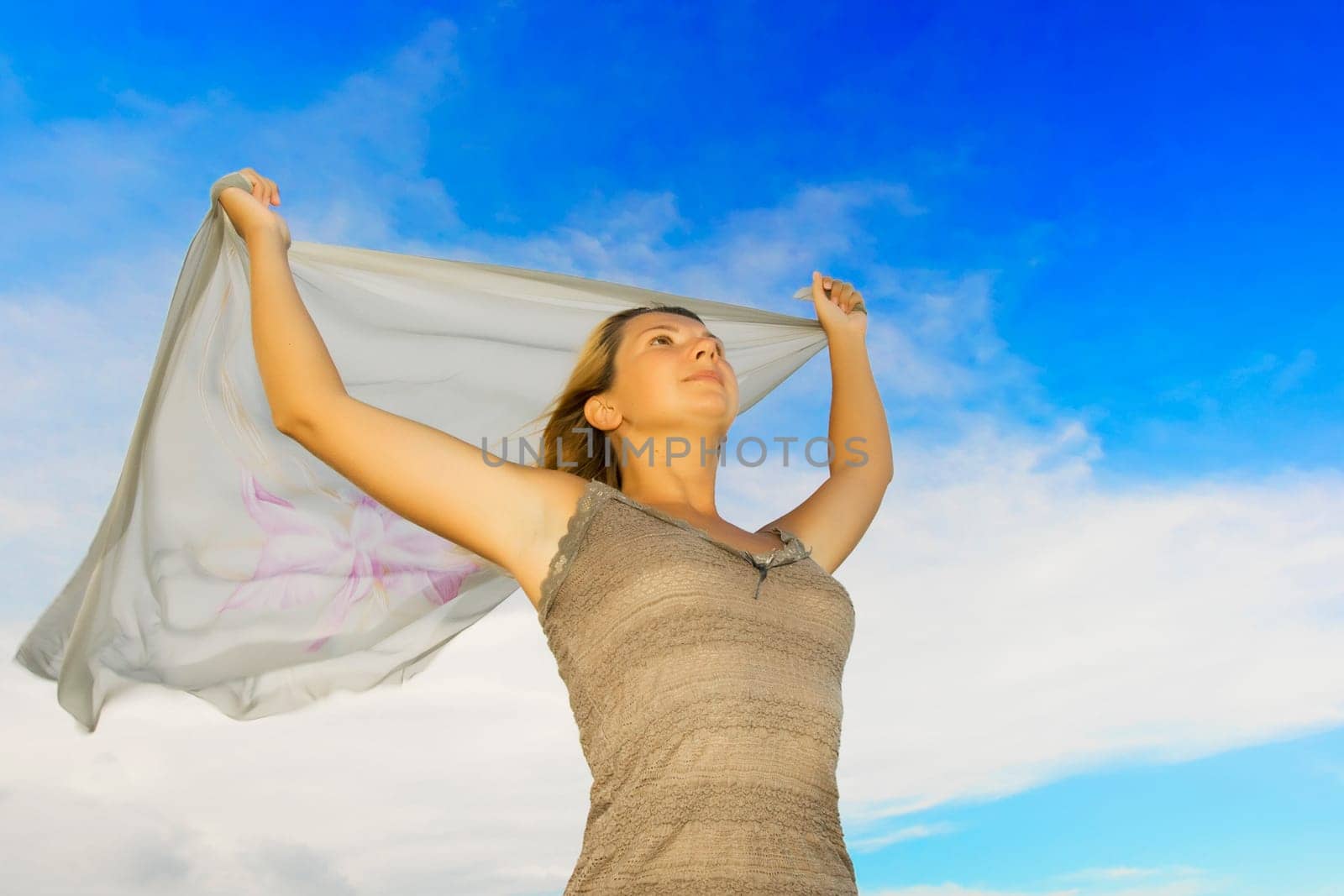 Girl with scarf on cloudy sky background
