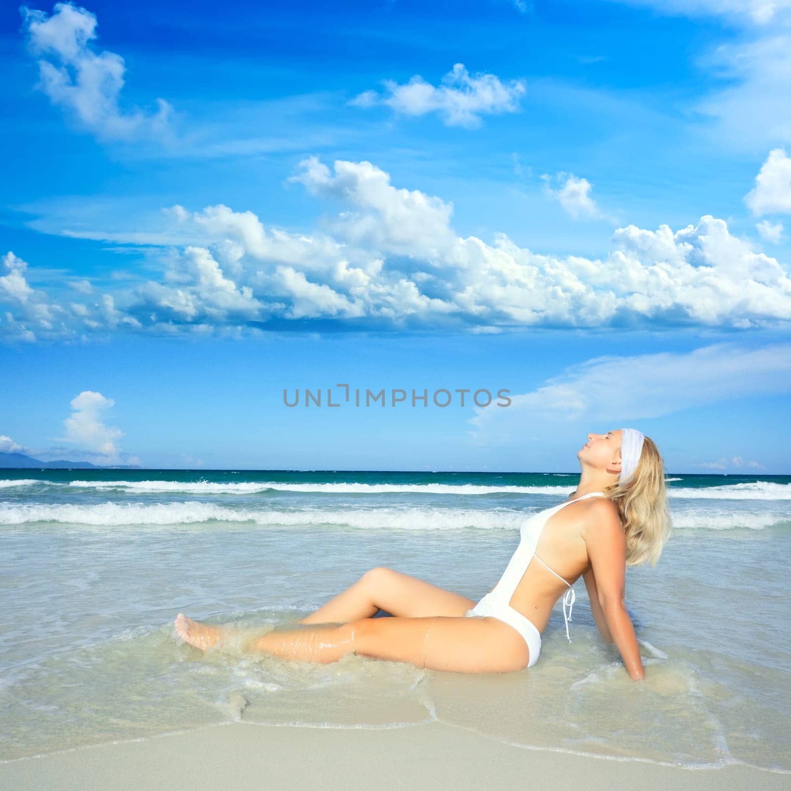 Woman sunbathimg near the ocean at day time