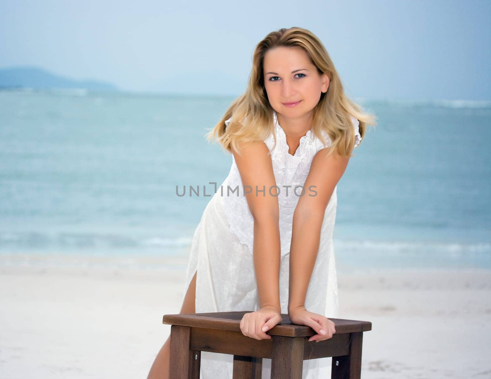 Young fashion woman posing on the white sandy beach