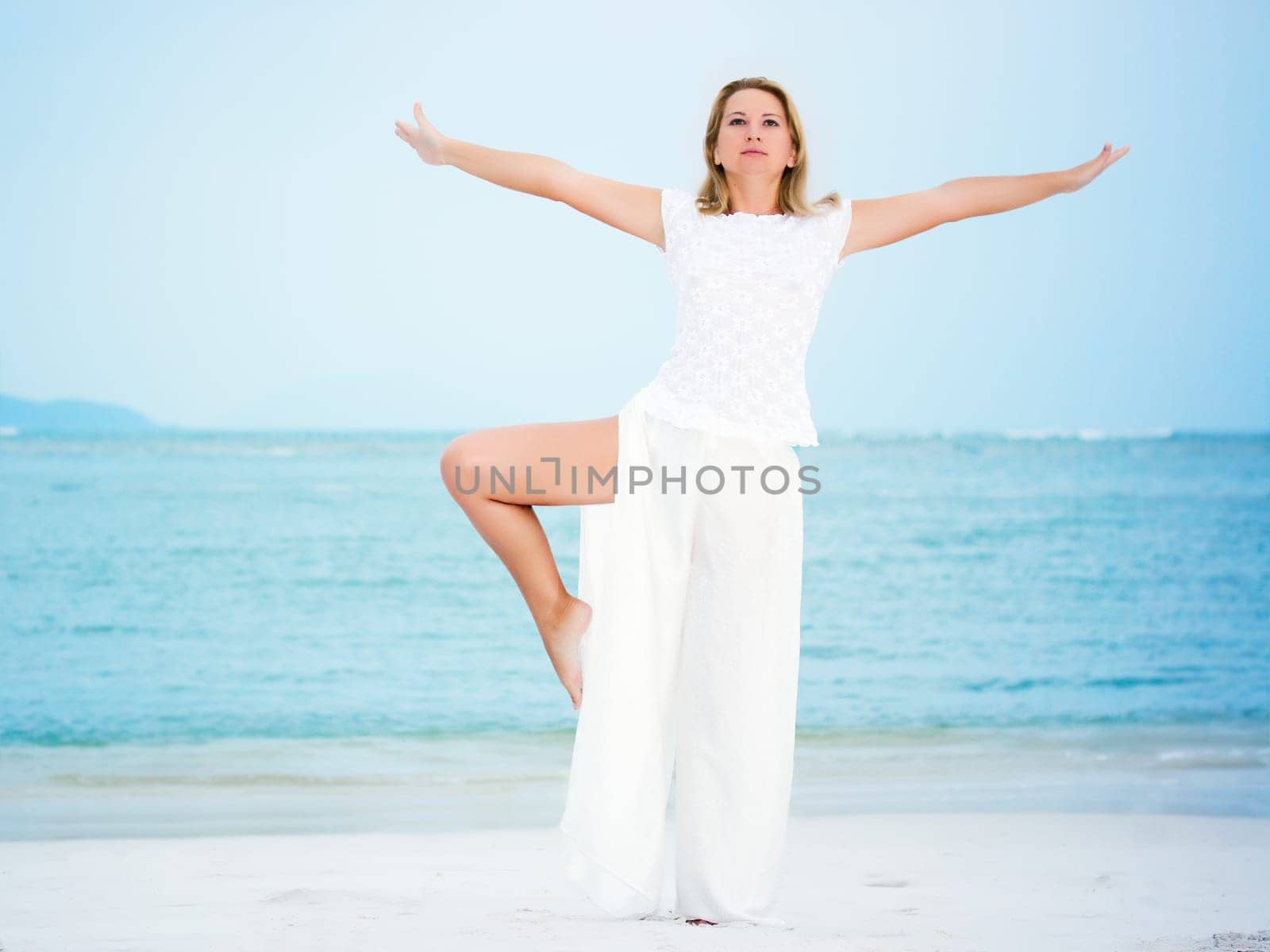 Young fashion woman posing on the white sandy beach