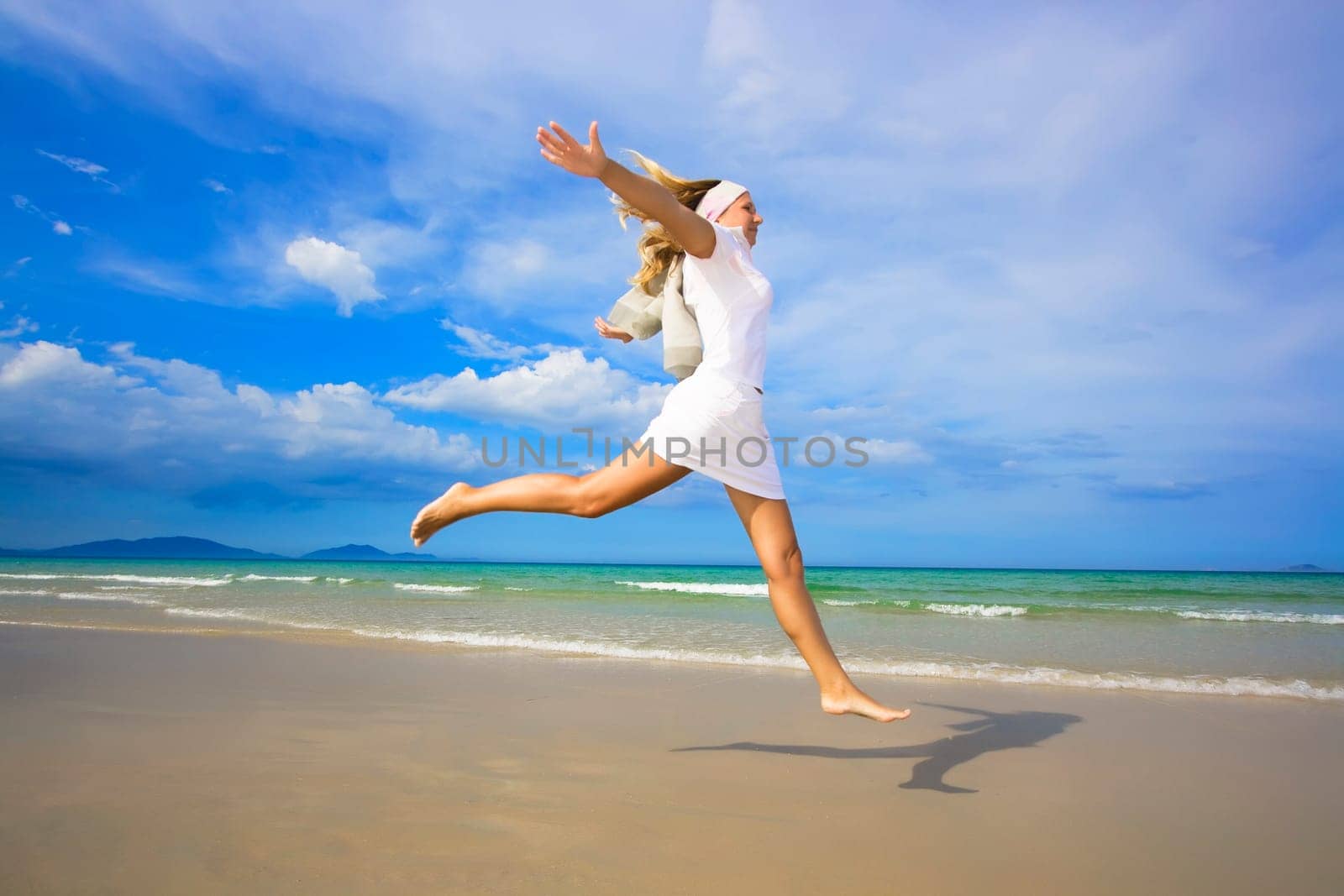 Young woman jumping on the tropical beach