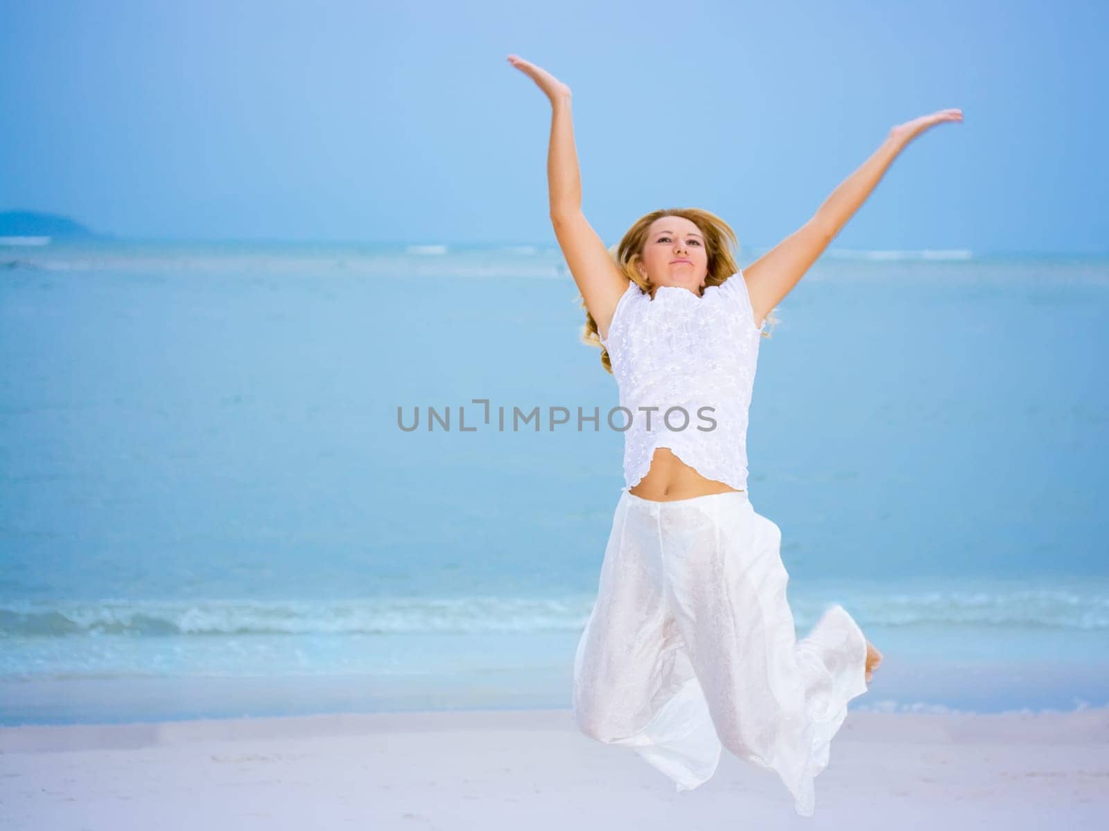 Young woman jumping on the tropical beach