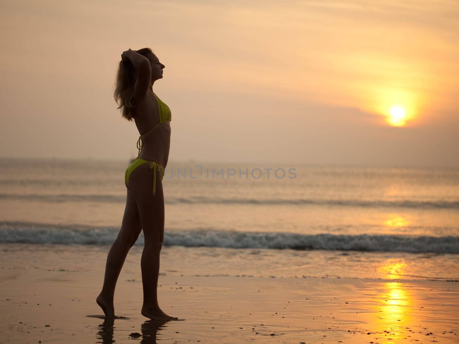 Woman near the ocean at sunrise time