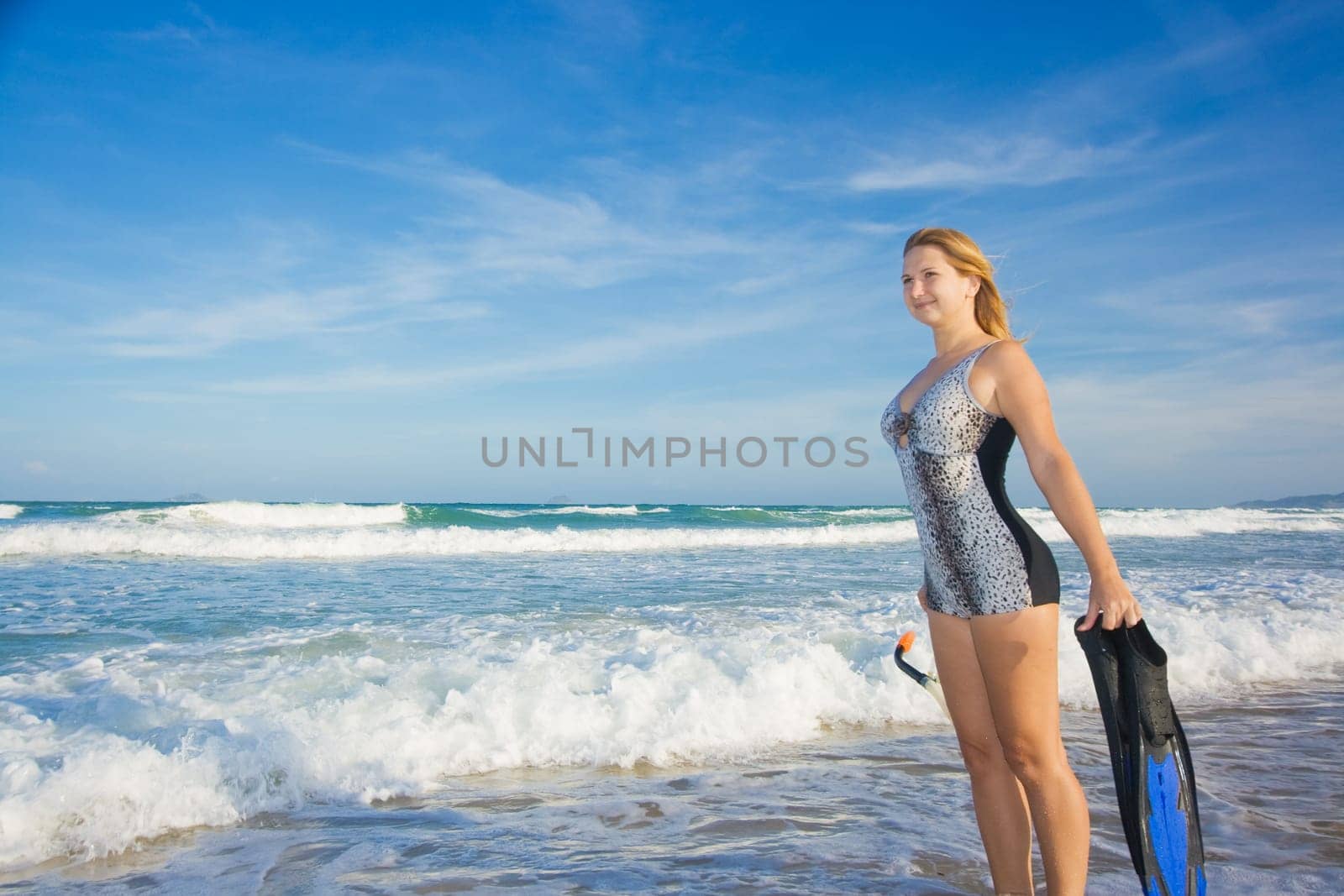 Young woman with snorkeling equipment near ocean