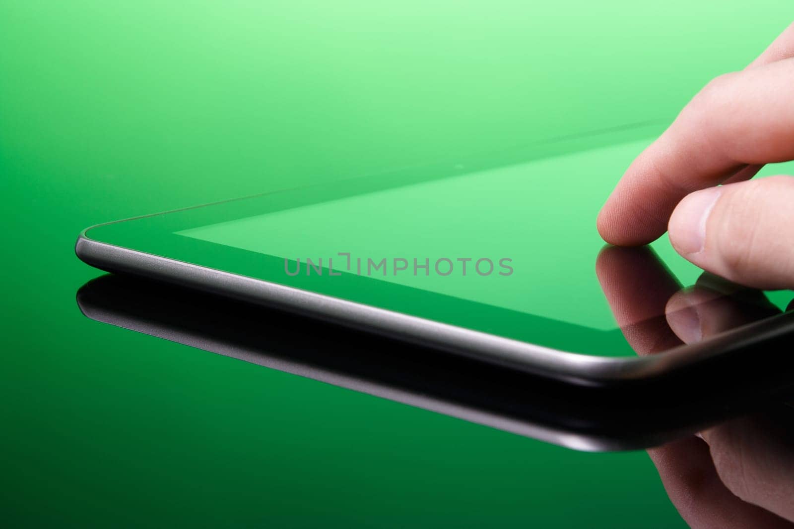 Digital publishing is green (ecological) concept. Man working with tablet computer (green tint). Touching screen on tablet PC.