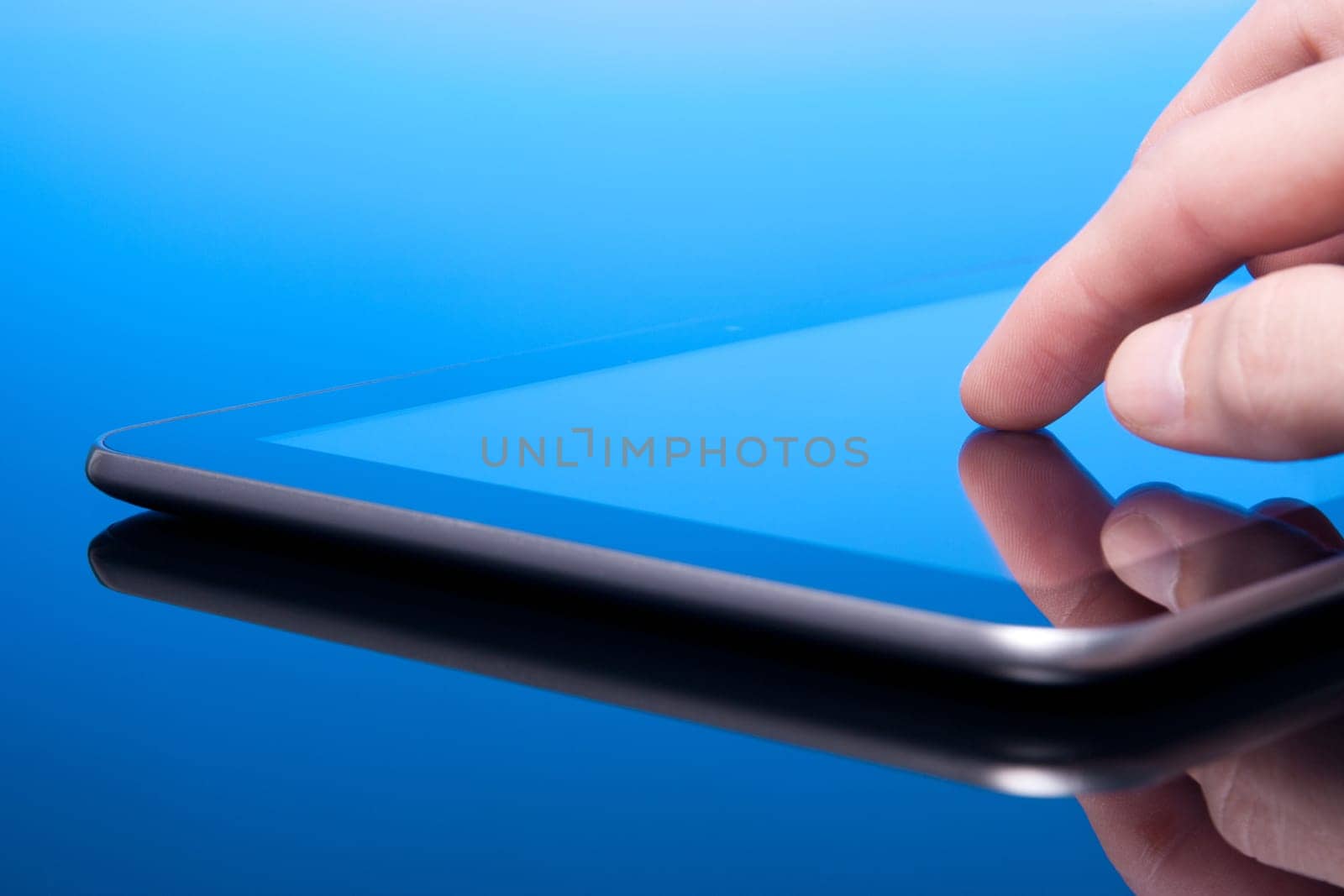 Man working with tablet computer (blue tint). Touching screen on tablet PC.