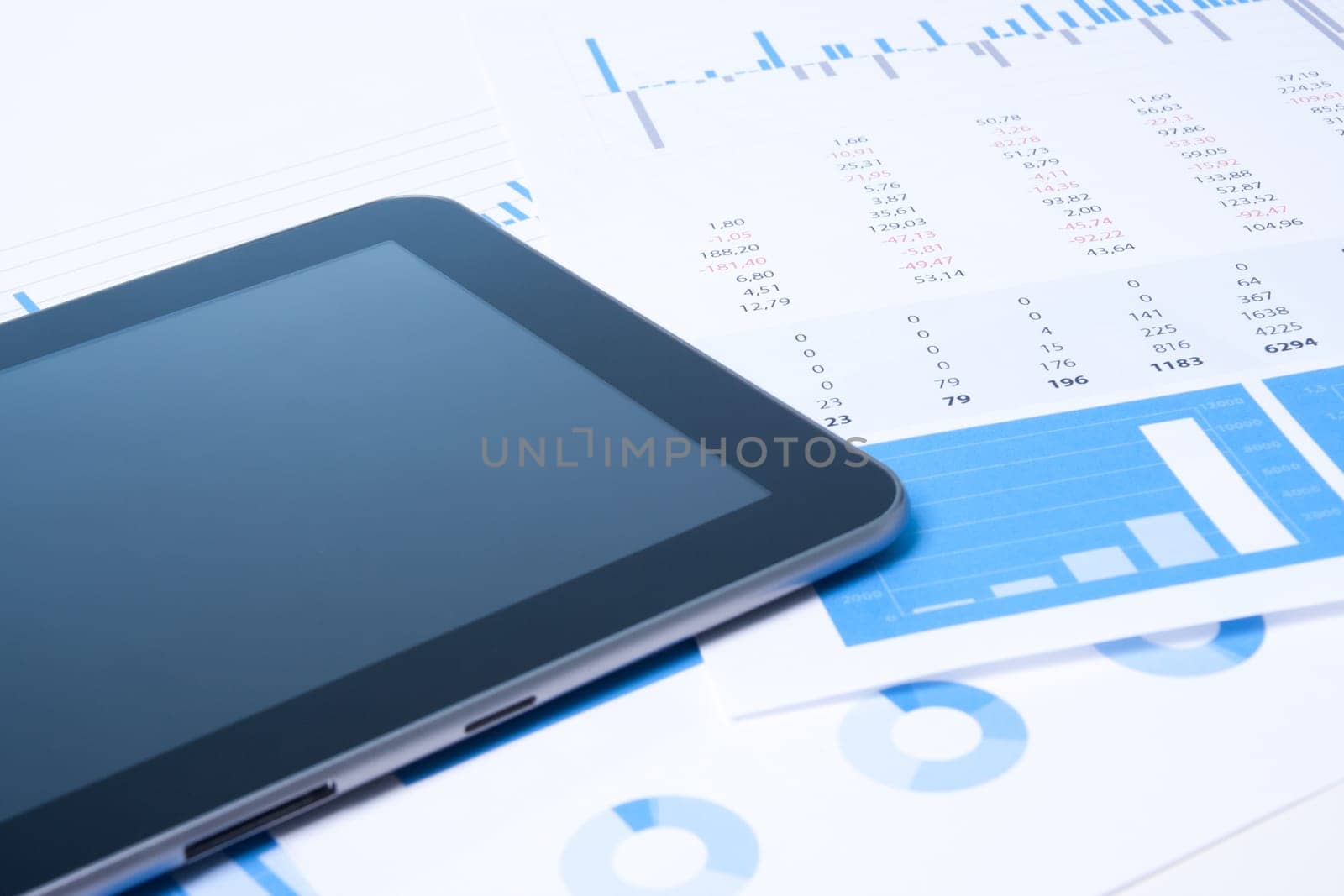 Modern business analysis with digital tablet computer, sheet and graphs.