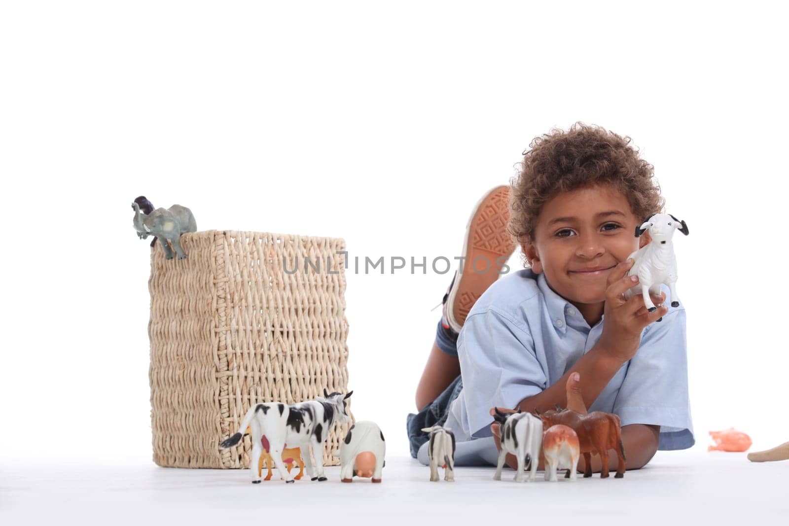 Little boy playing with plastic toy animals