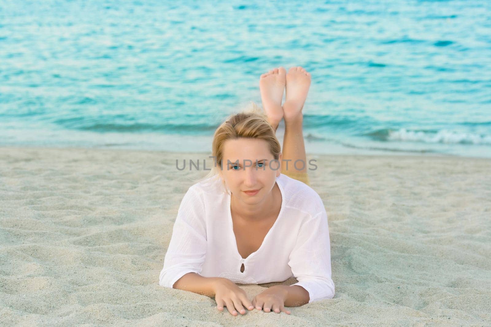 Young woman relaxing near ocean on sandy beach