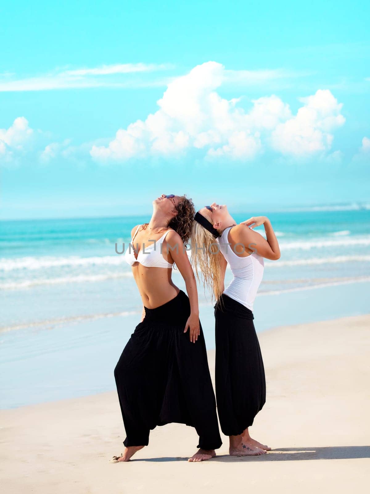 Two young beautiful woman in cambodian pants near the ocean