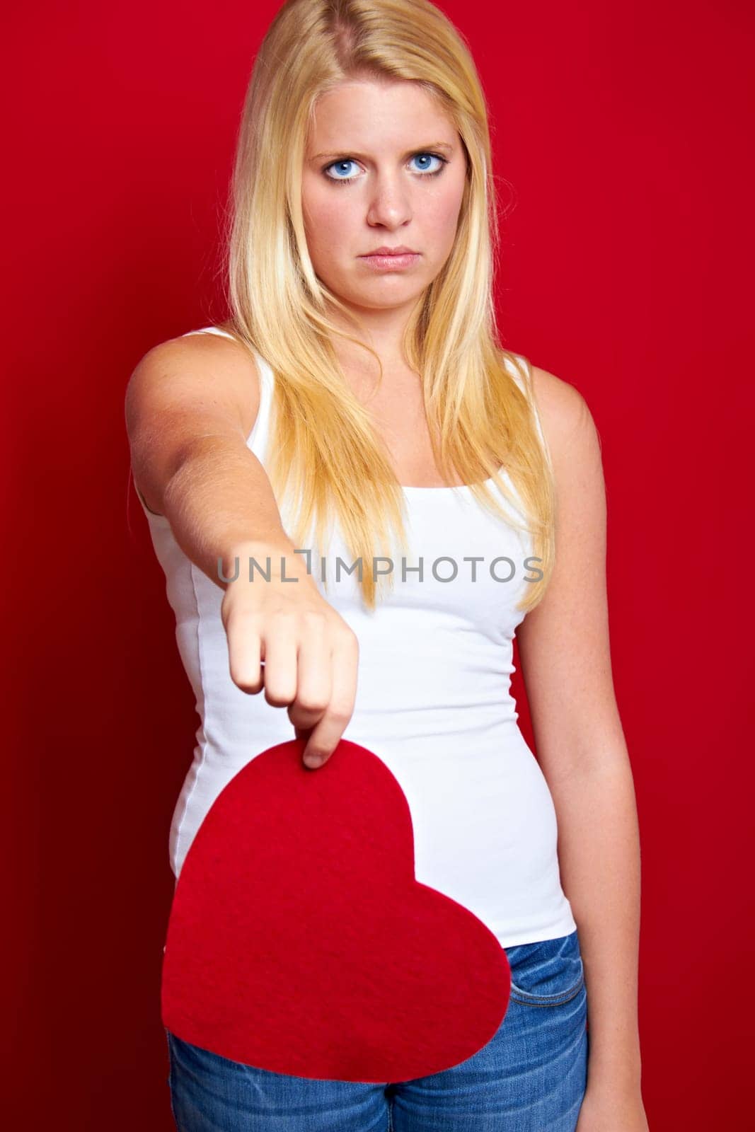 Young blonde woman with red heart in hands
