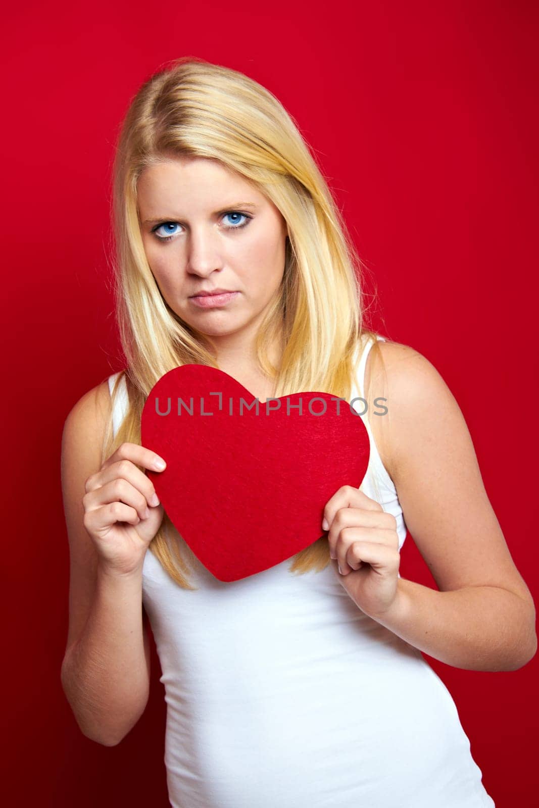Young blonde woman with red heart in hands