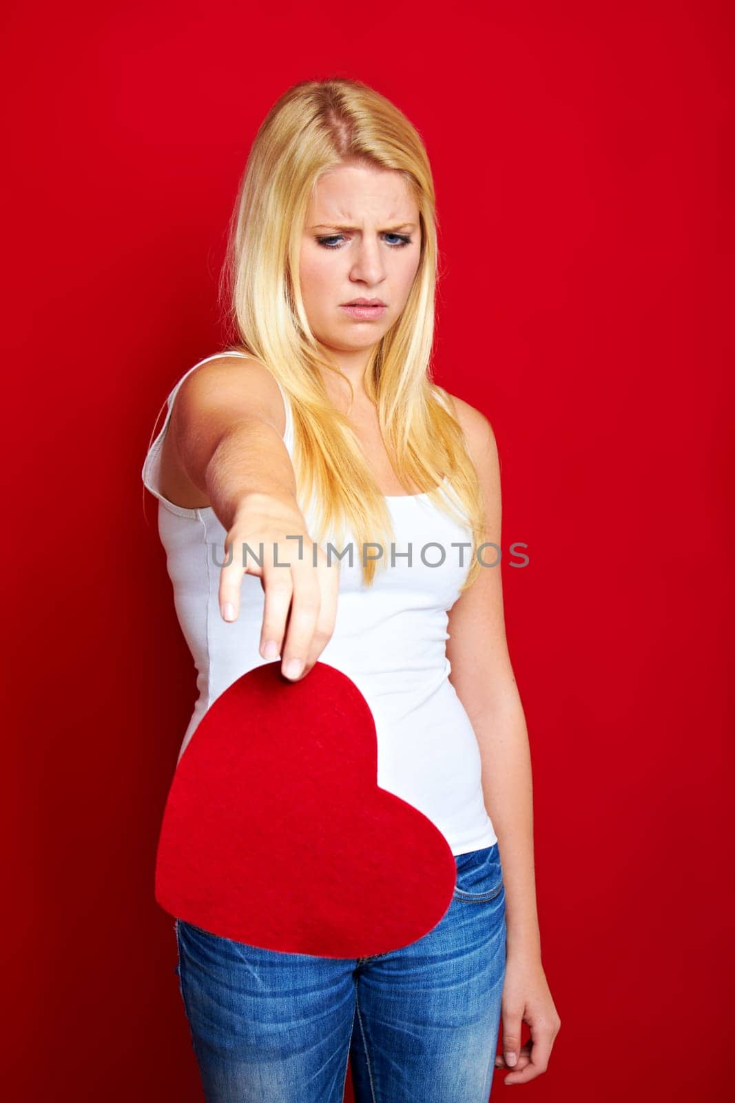 Young blonde woman with red heart in hands