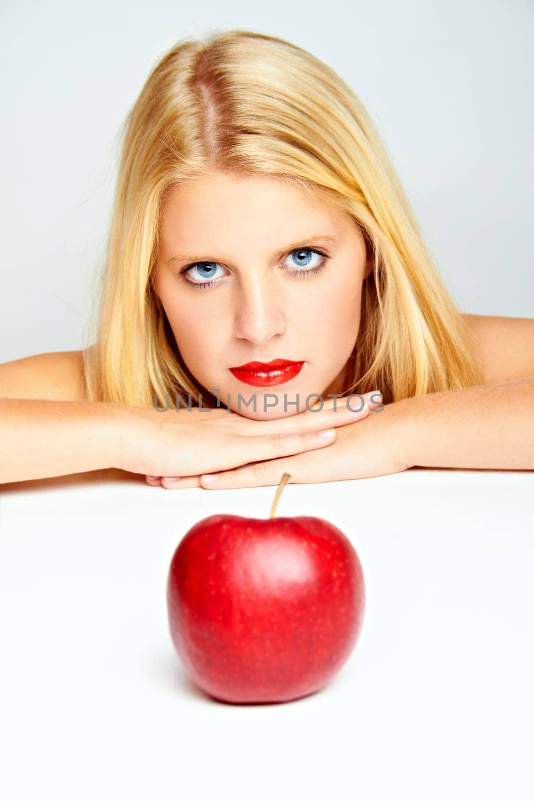 Young beautiful laughing girl with apple against white background