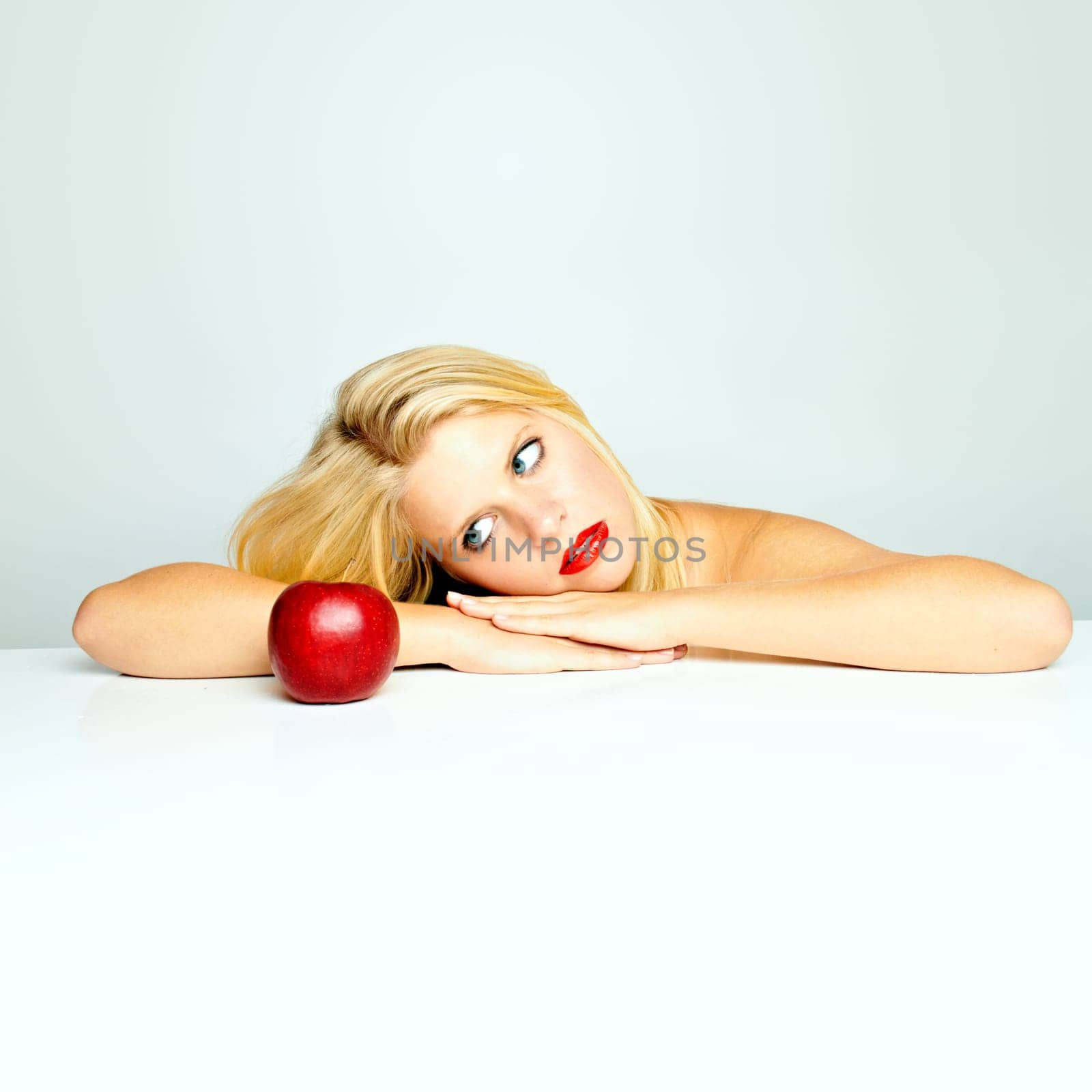 Young beautiful laughing girl with apple against white background
