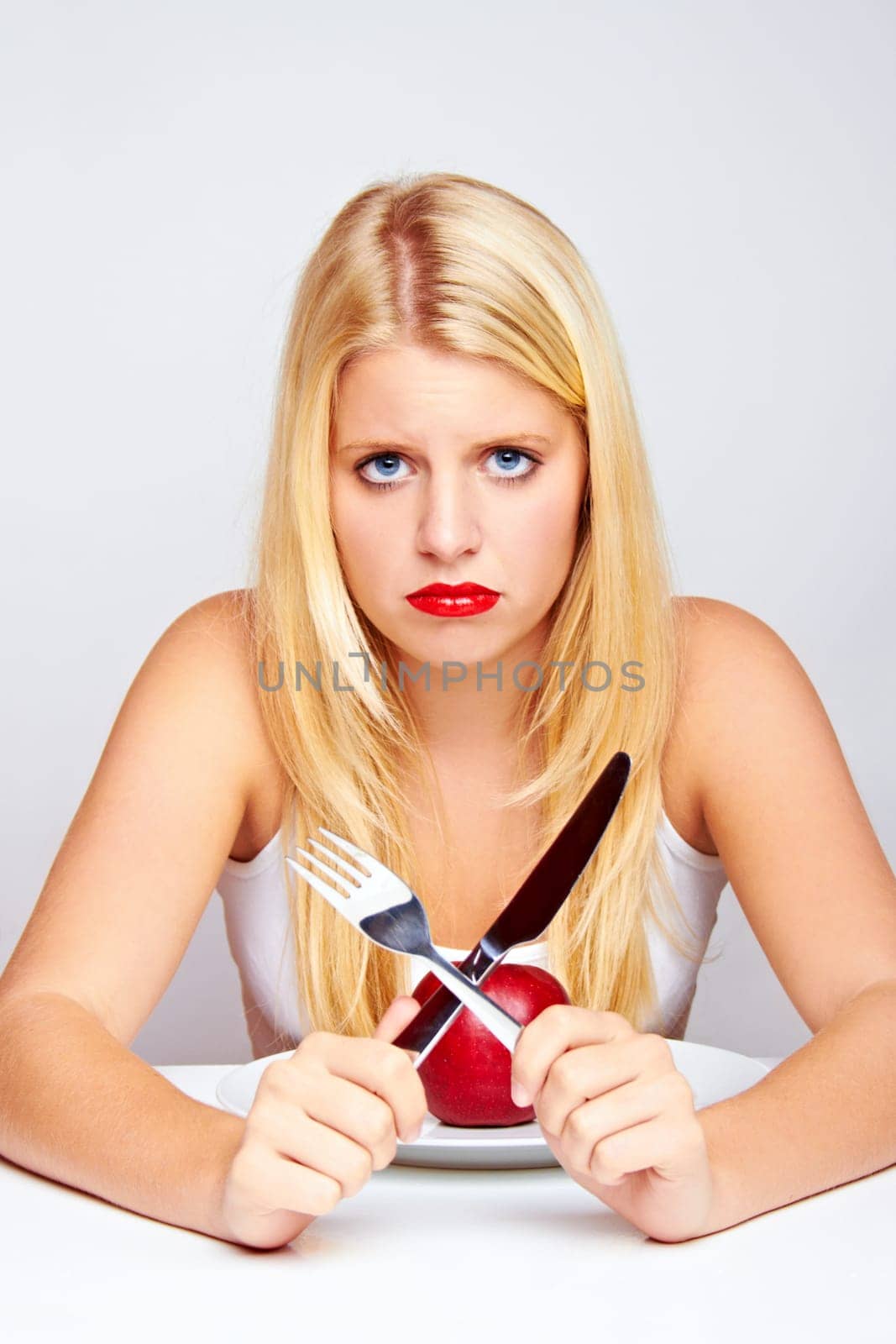 Happy young woman eating fruit with cutlery