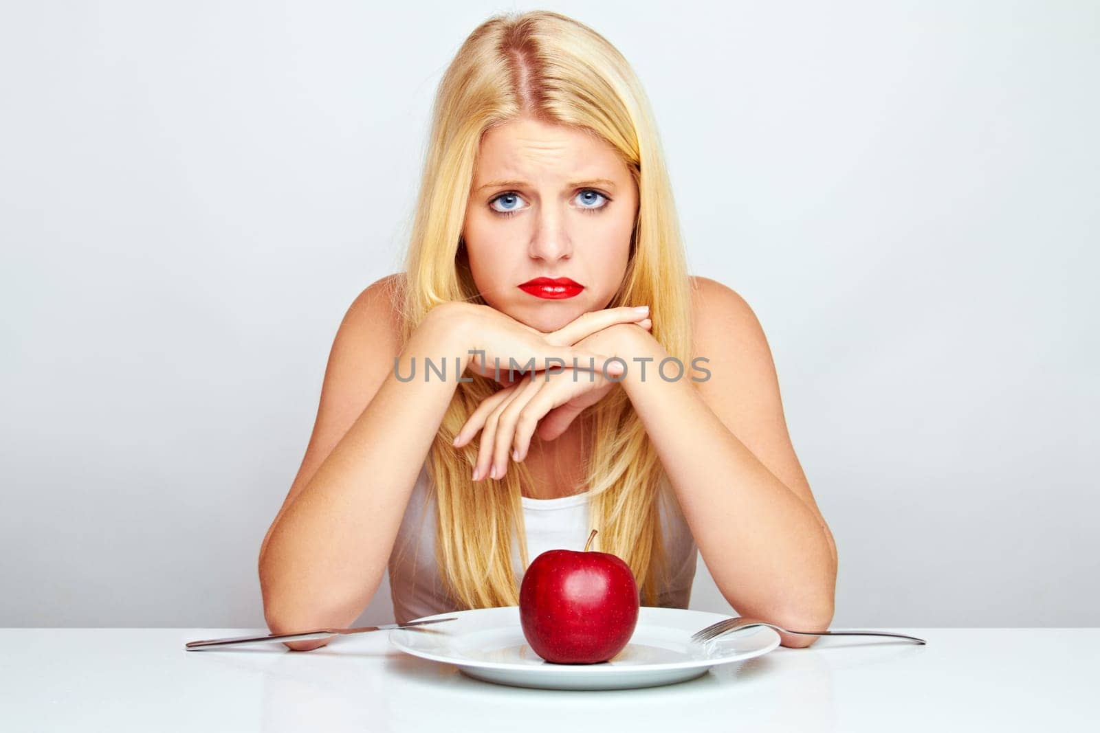 Happy young woman eating fruit with cutlery