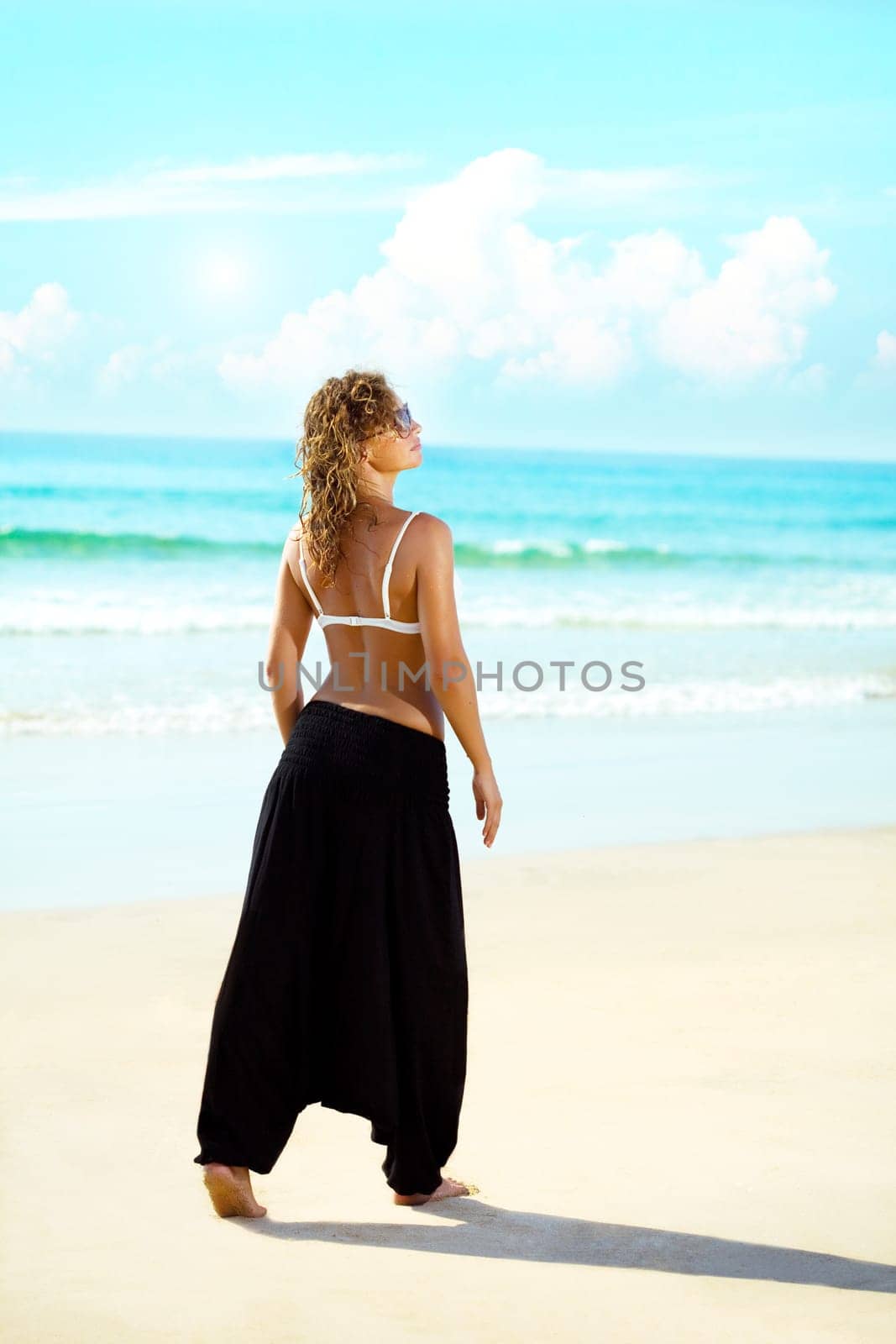 beautiful young woman walking near the ocean