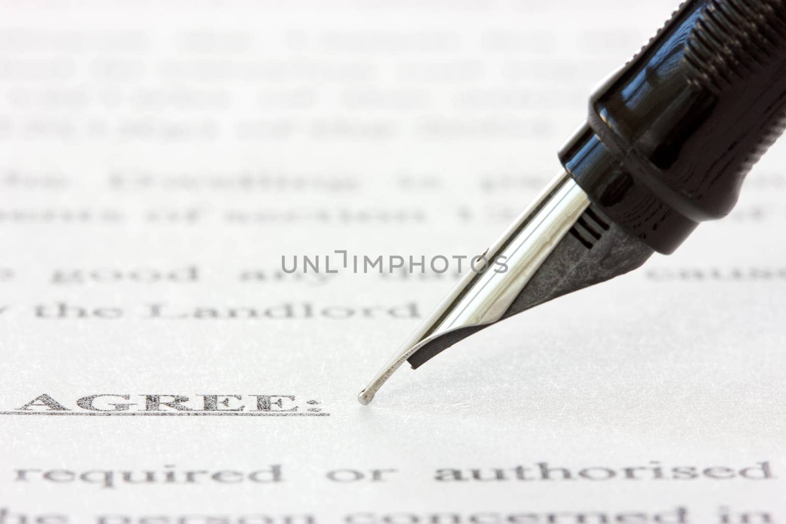 black ink pen over a printed agreement