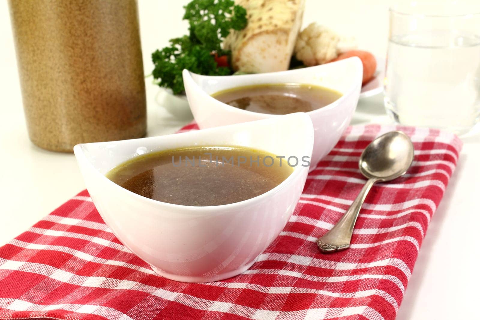 two bowls of beef consommé on a napkin