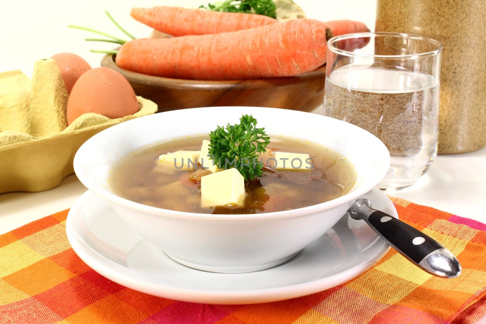 a bowl of beef consommé with egg custard and parsley