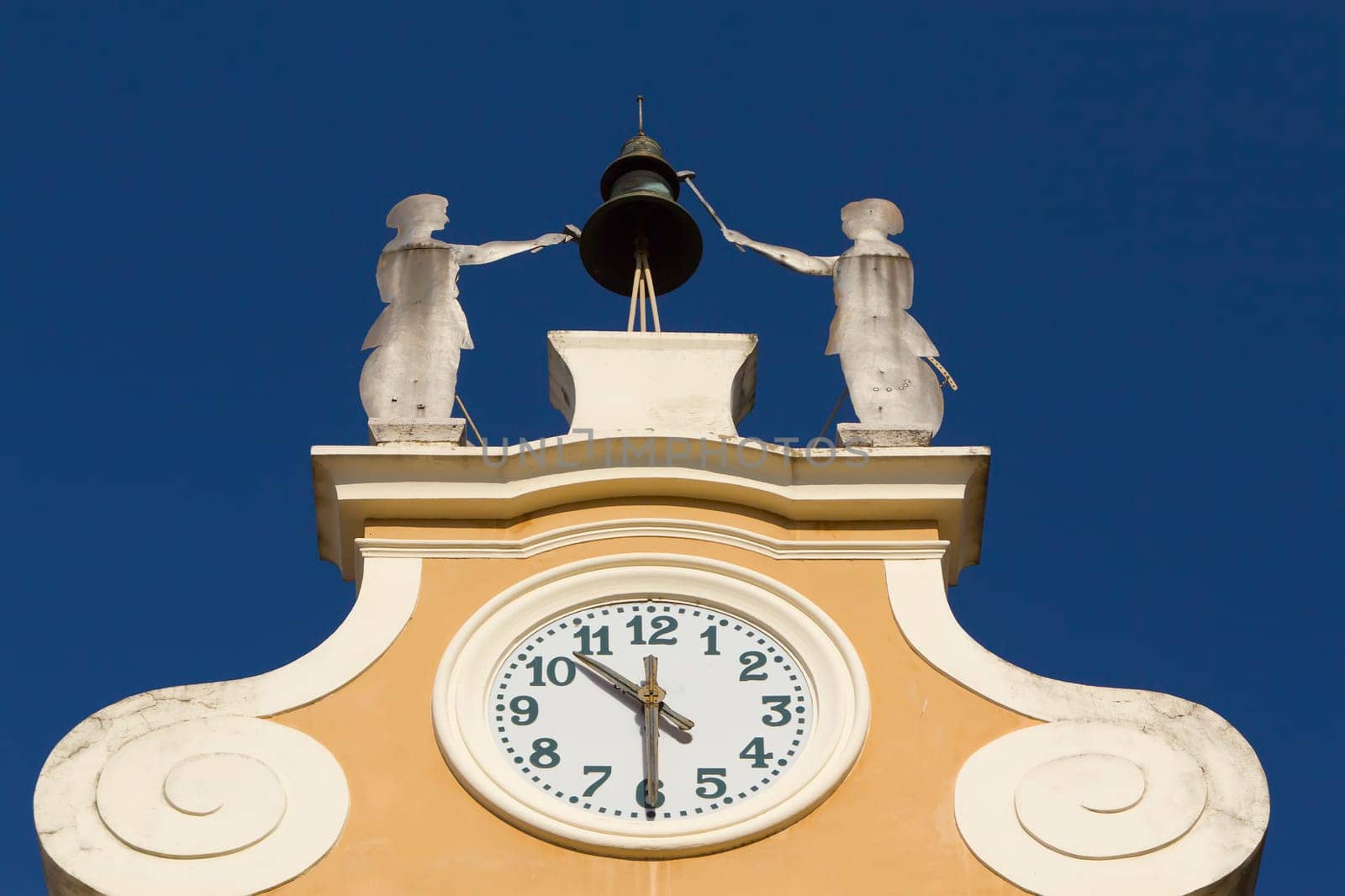 Clock Tower at Town Hall. Above the clock&#039 s bell and figures of two craftsmen. (Bardolino, Lake Garda, Italy)
