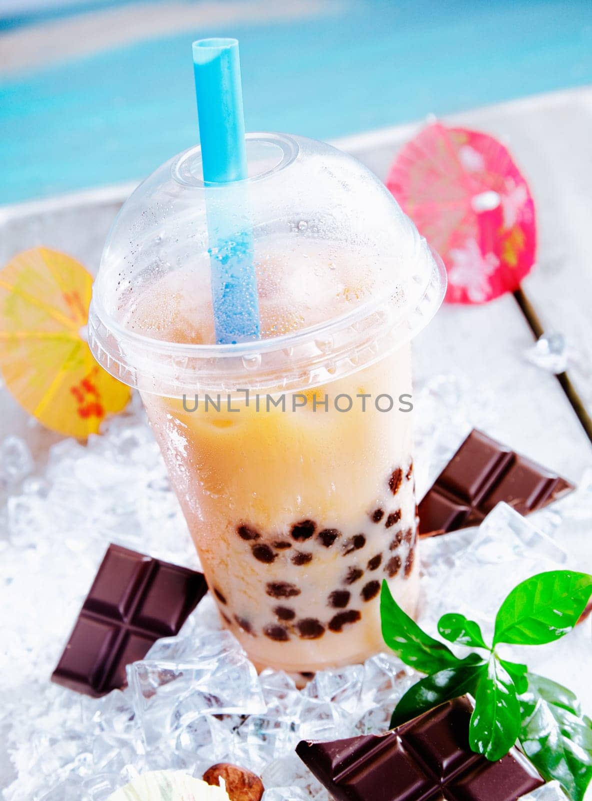 Refreshing sherbet drink with bits of chocolate served in a domed cup with a straw on a hot day