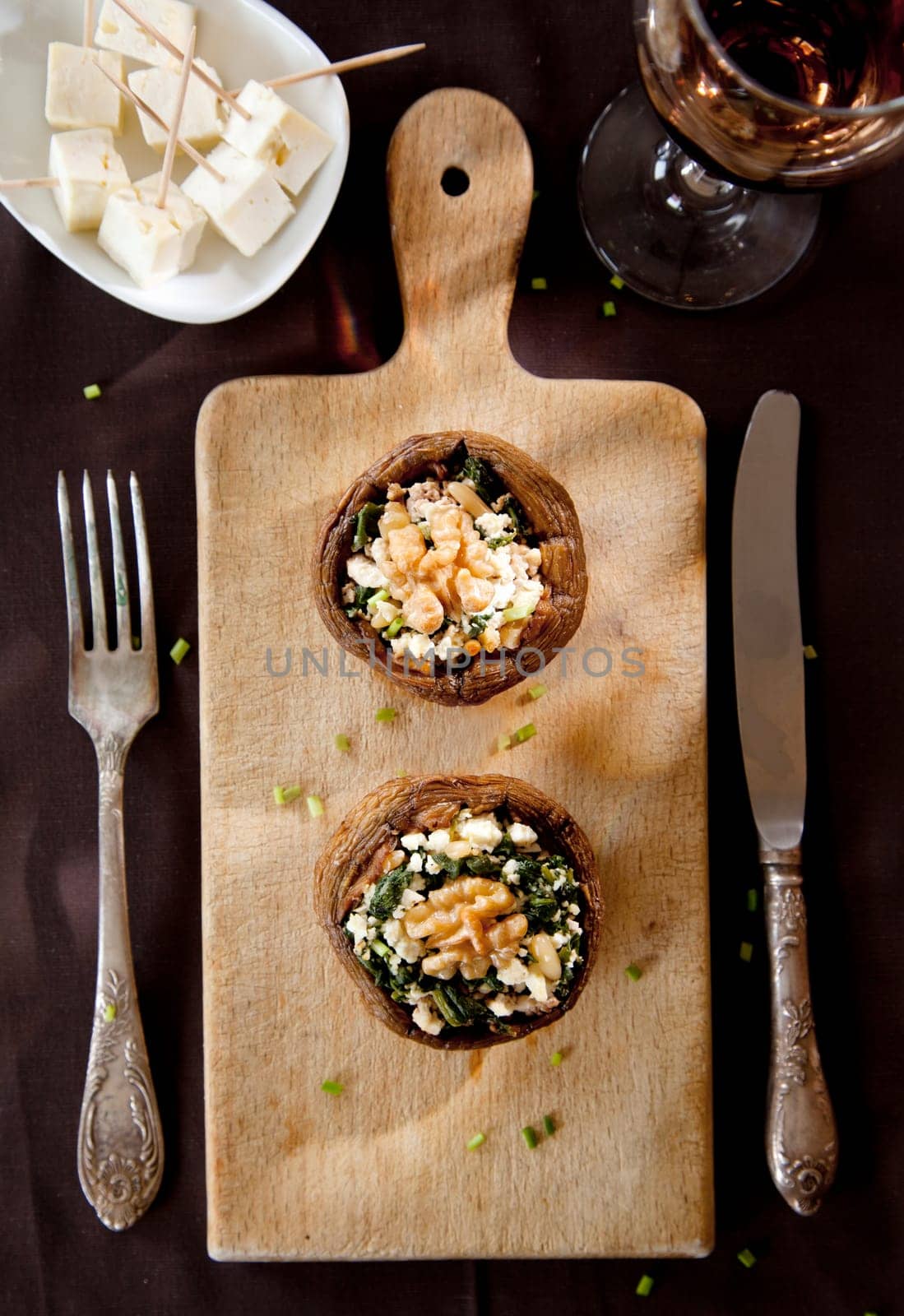Filled mushroom with cheese on wooden breadboard