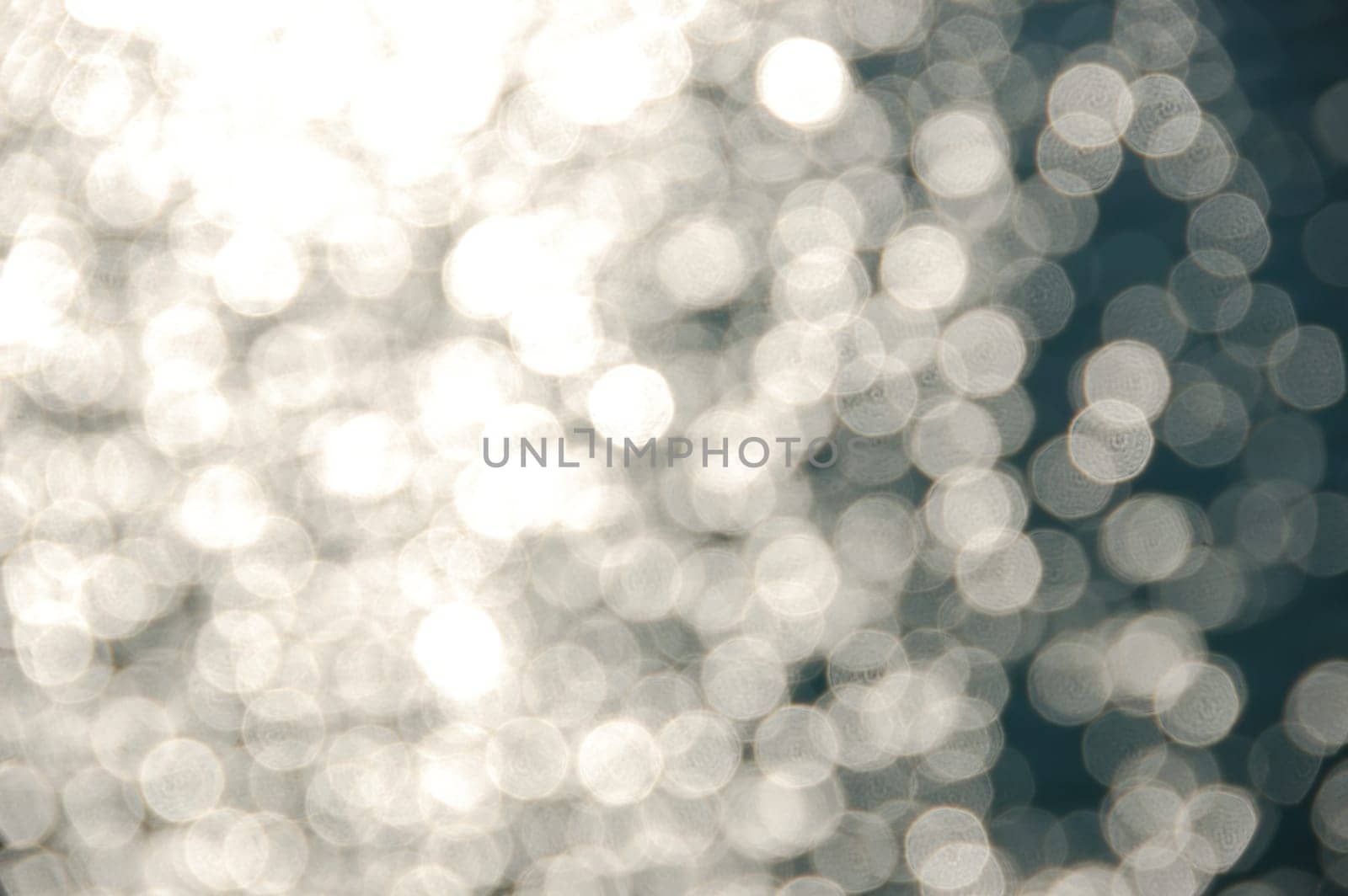 Light shining on sea water. Blurry reflections on sunny day abstract background.