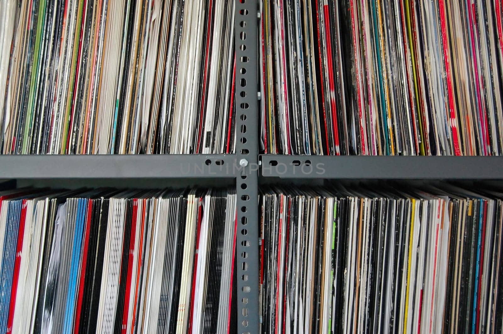 Vinyl music records storred on metal shelves.