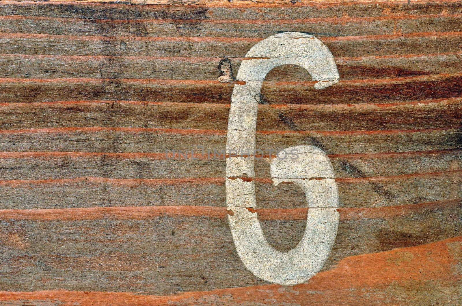 Old wooden board with number six faded stencil. Wood grunge background.