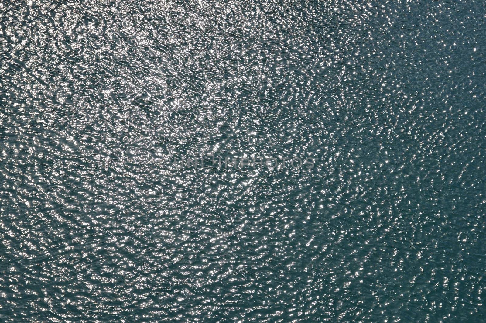 Sunshine on sea water. Light reflection on bright day ocean background.