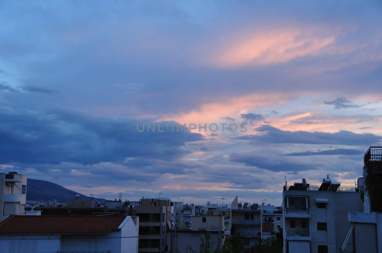 Dawn over the city of Athens, Greece. Sunrise colors and cloudy sky.